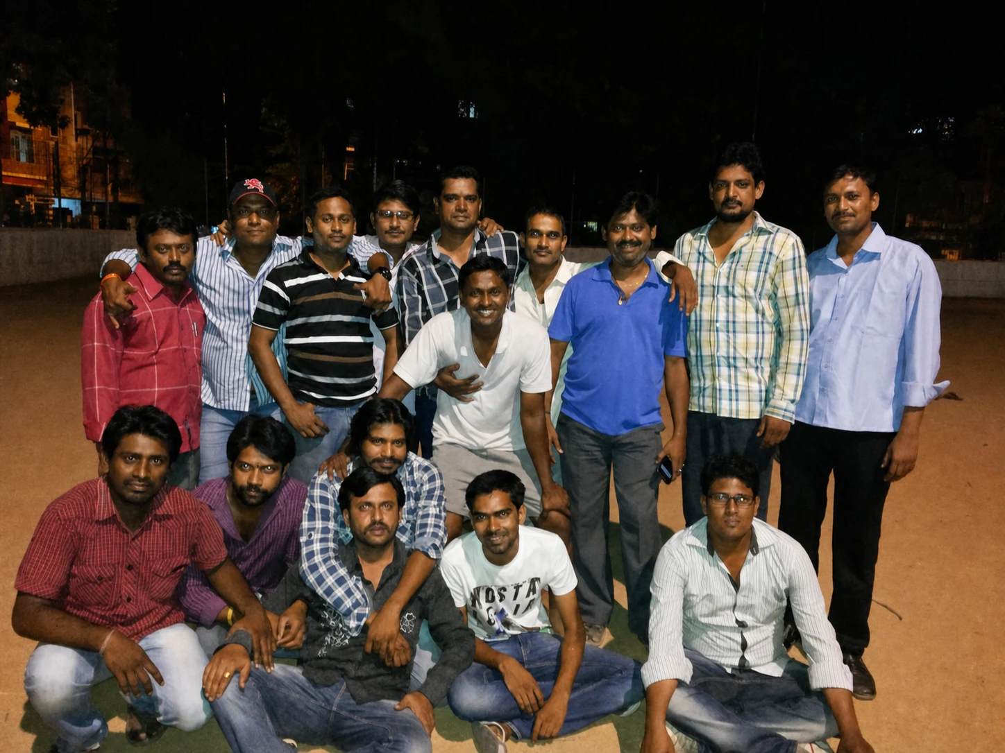 Friends assembled for a group portrait on the open ground at night