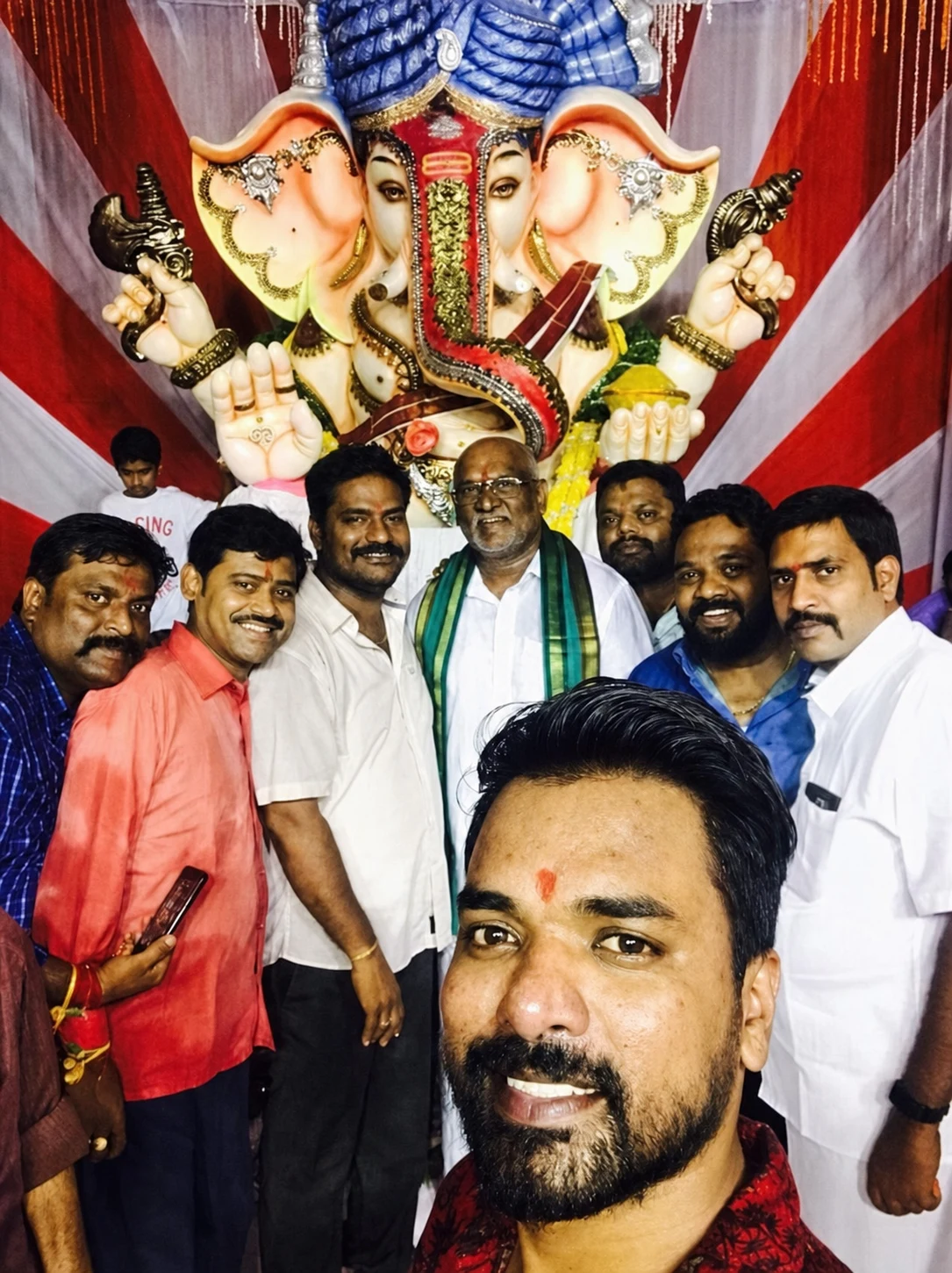 A group portrait in front of a Ganesh idol and festival drapery